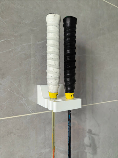 White 3D Printed Wall Mount Badminton Racket Holder installed on a wall with a badminton racket.